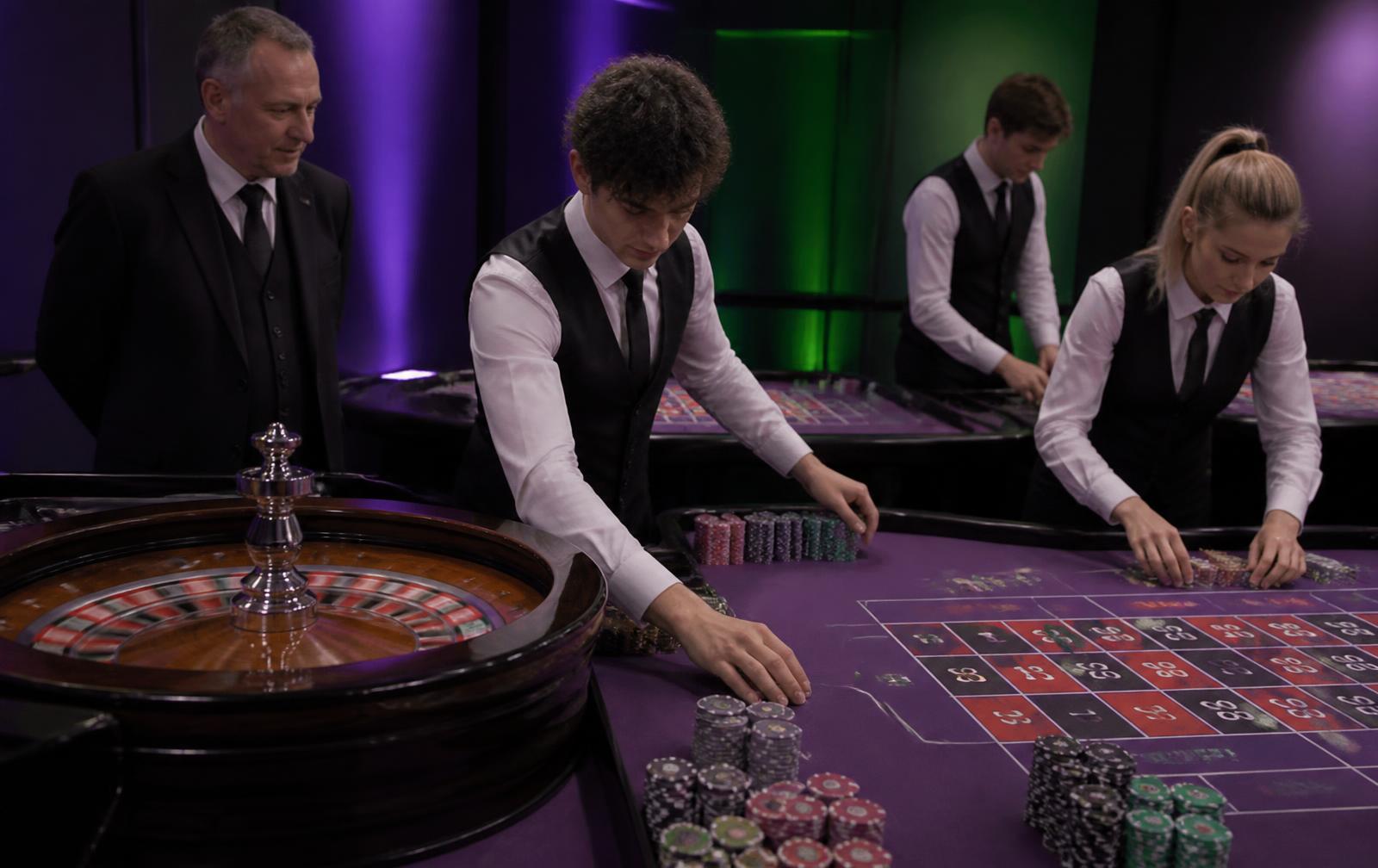 A instructor coaching learners at a Swissbirch blackjack and roulette practice pit